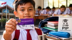 Seorang siswa menunjukkan kartu Program Indonesia Pintar (PIP) sebagai simbol bantuan pendidikan bagi peserta didik dari keluarga rentan.